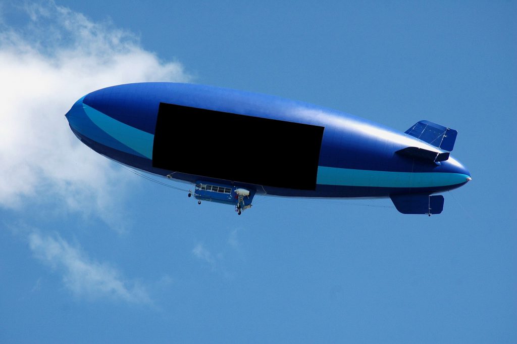 Sterowiec reklamowy (blimp) z dużą pustą tablicą billboardową na kadłubie